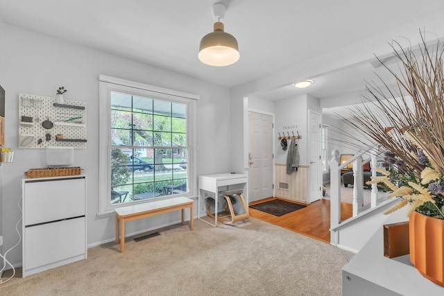foyer featuring visible vents, carpet floors, and baseboards