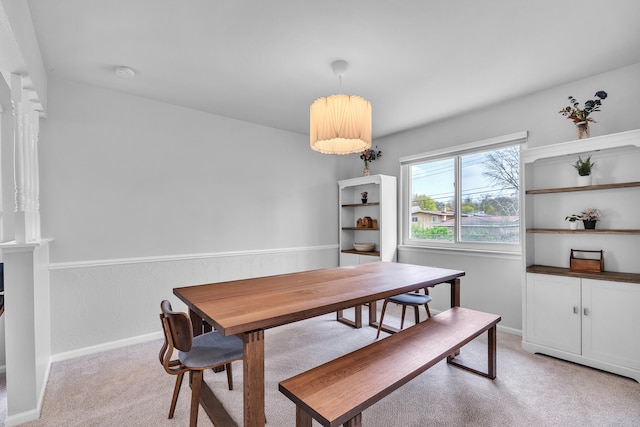 dining room featuring light colored carpet and baseboards