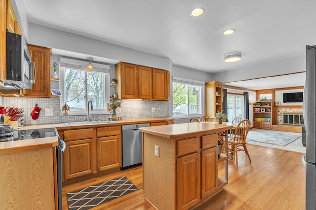 kitchen with tasteful backsplash, open shelves, a sink, appliances with stainless steel finishes, and a center island