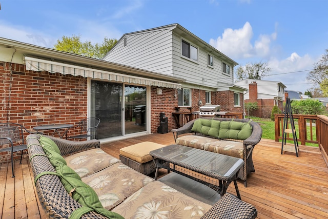 wooden terrace with grilling area and an outdoor living space