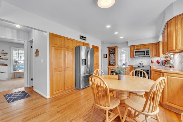 dining room with recessed lighting, baseboards, and light wood-style floors