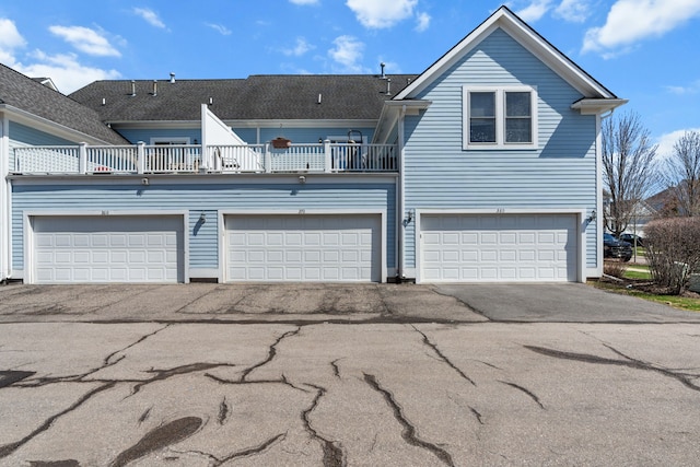 view of front facade featuring aphalt driveway and a balcony