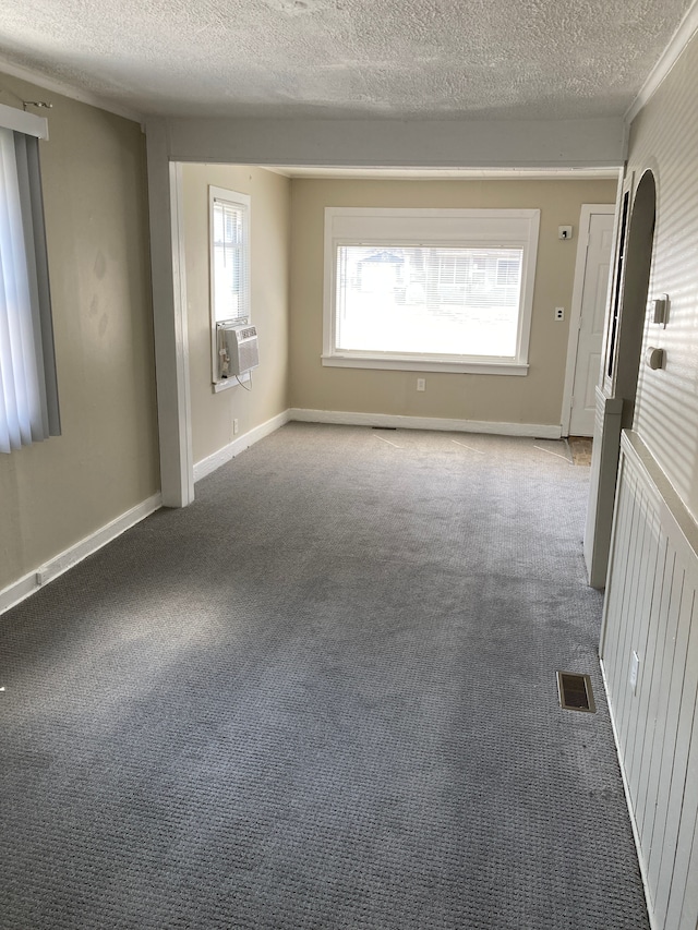unfurnished room featuring a textured ceiling, visible vents, and carpet flooring