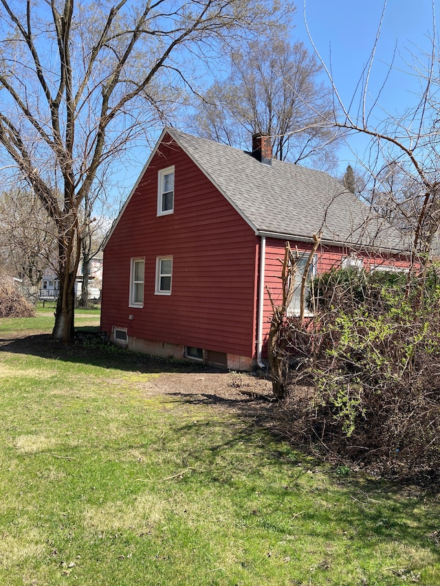 view of property exterior featuring roof with shingles, a yard, and a chimney