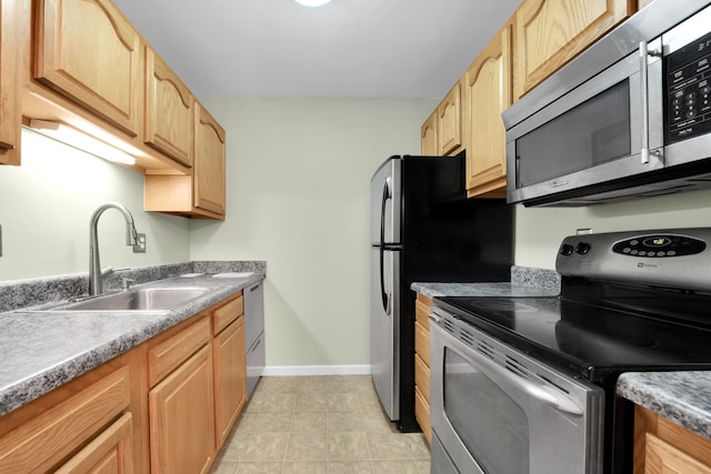 kitchen with a sink, appliances with stainless steel finishes, light tile patterned floors, and light brown cabinets