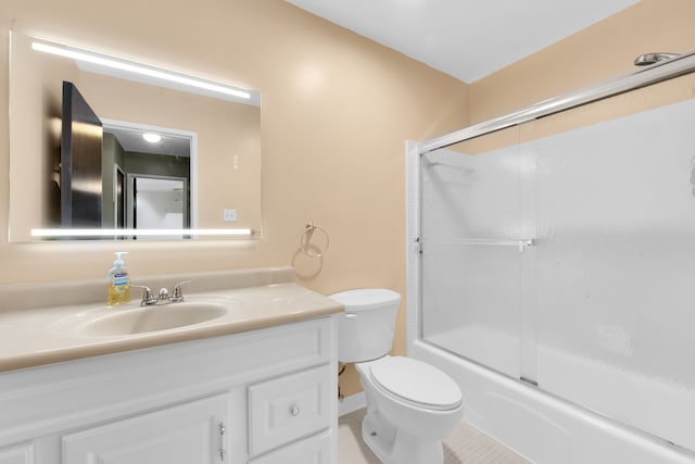 full bathroom with vanity, shower / bath combination with glass door, tile patterned floors, and toilet