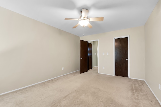 unfurnished bedroom featuring baseboards, a ceiling fan, and light carpet
