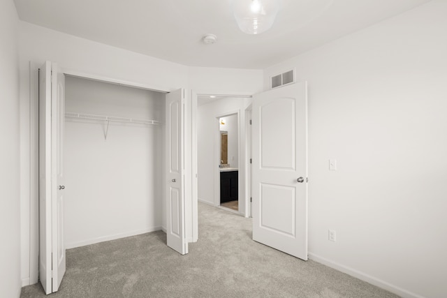 unfurnished bedroom with a closet, visible vents, carpet floors, and baseboards