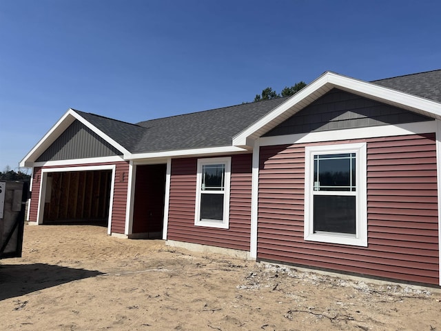 view of front of property featuring an attached garage and roof with shingles
