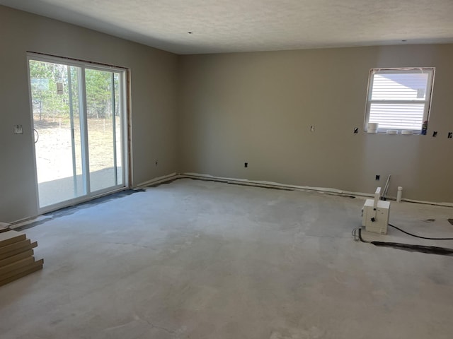 empty room featuring plenty of natural light and baseboards