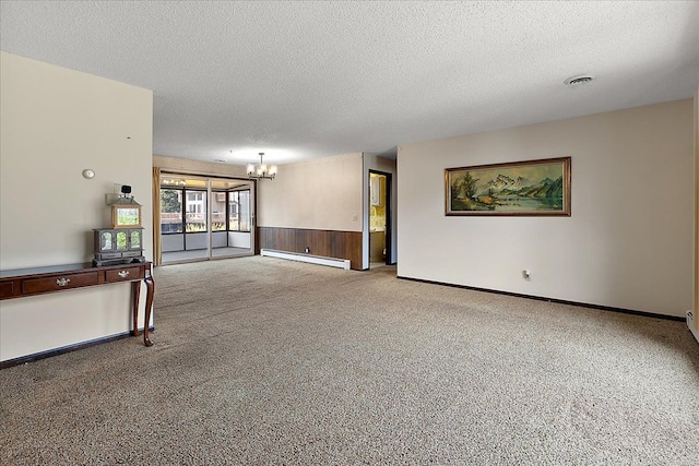 interior space featuring a textured ceiling, visible vents, baseboard heating, an inviting chandelier, and carpet