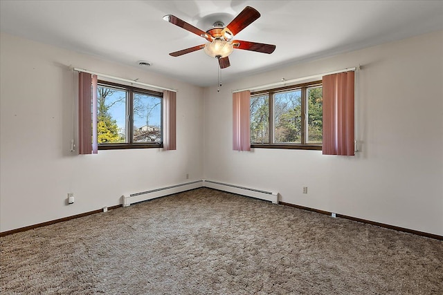 carpeted empty room featuring a ceiling fan, baseboards, a baseboard heating unit, and a healthy amount of sunlight