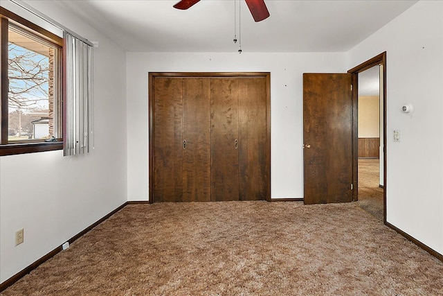 unfurnished bedroom featuring a closet, carpet, ceiling fan, and baseboards