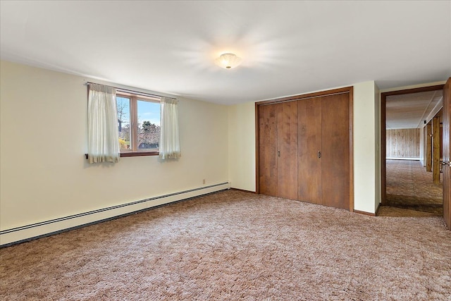 unfurnished bedroom with a baseboard radiator, carpet, and a closet
