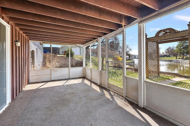unfurnished sunroom featuring a water view