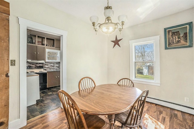 dining room with an inviting chandelier, dark wood-style flooring, and a baseboard radiator
