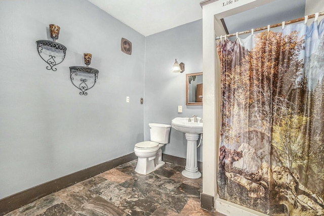 full bath featuring toilet, marble finish floor, curtained shower, and baseboards