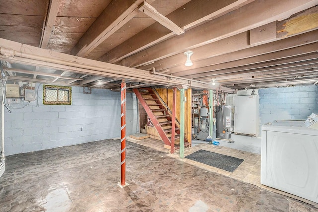 unfinished below grade area featuring stairway, independent washer and dryer, and water heater