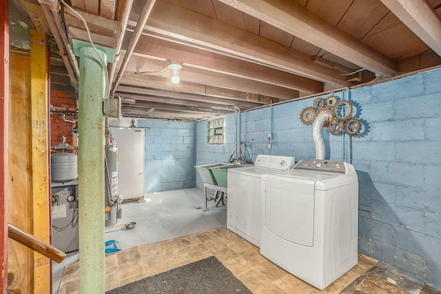 laundry area with gas water heater, separate washer and dryer, laundry area, and a sink