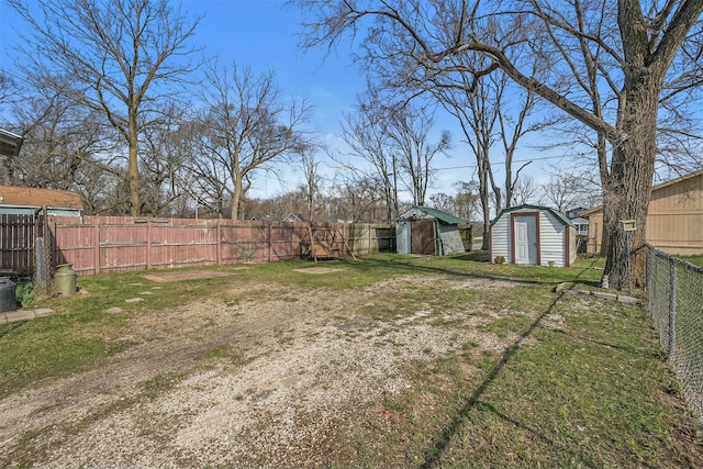view of yard with an outbuilding, a storage unit, and a fenced backyard