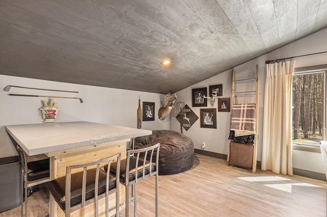 interior space with light wood finished floors, wood ceiling, vaulted ceiling, and baseboards