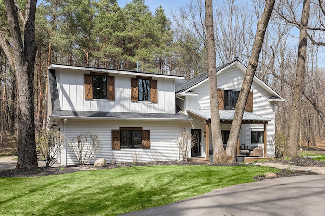 view of front facade featuring board and batten siding and a front lawn