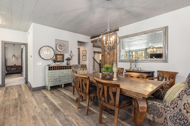 dining room with wood finished floors, a chandelier, and baseboards