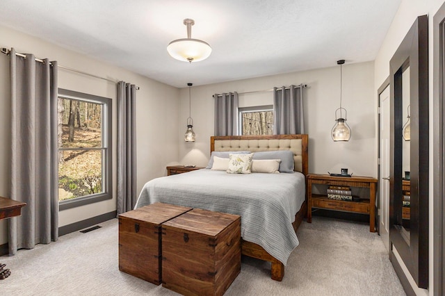 bedroom featuring baseboards, visible vents, and light carpet