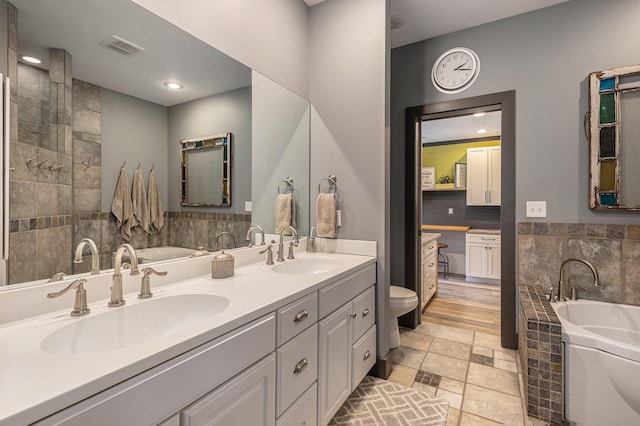 full bathroom with a garden tub, tile walls, and a sink