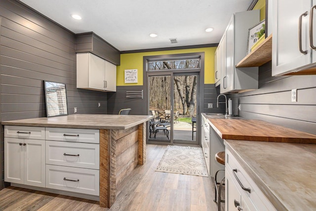 kitchen with a sink, plenty of natural light, light wood-style flooring, and butcher block counters
