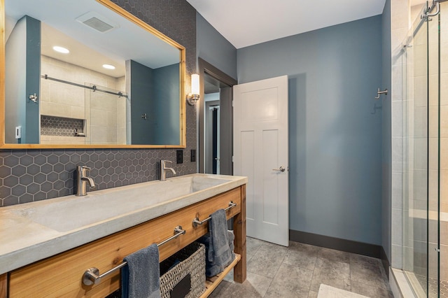 bathroom with baseboards, tasteful backsplash, a stall shower, and double vanity