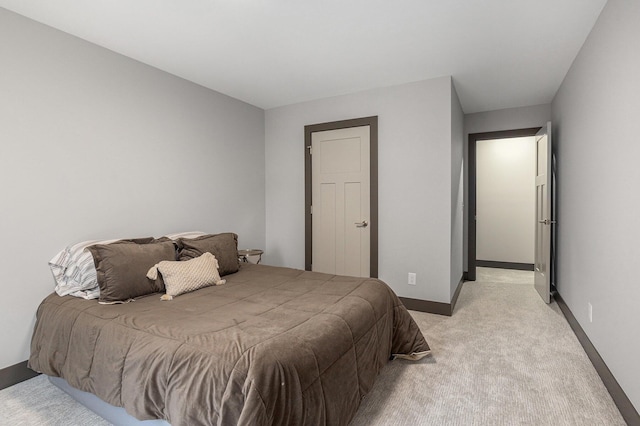 bedroom with light carpet and baseboards