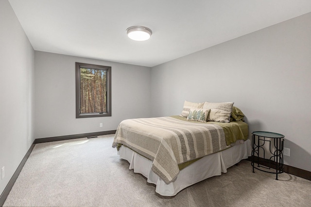 carpeted bedroom featuring visible vents and baseboards