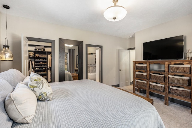 bedroom with a closet, light carpet, and a spacious closet