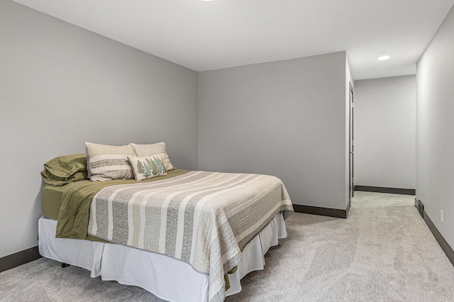 bedroom featuring light colored carpet and baseboards