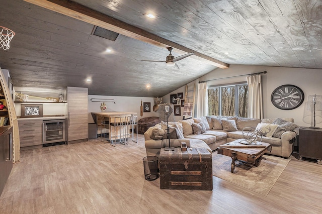 living room featuring beverage cooler, ceiling fan, a bar, light wood-type flooring, and vaulted ceiling with beams