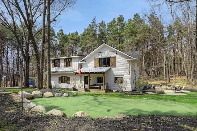 modern farmhouse with an outdoor living space, board and batten siding, and a patio area