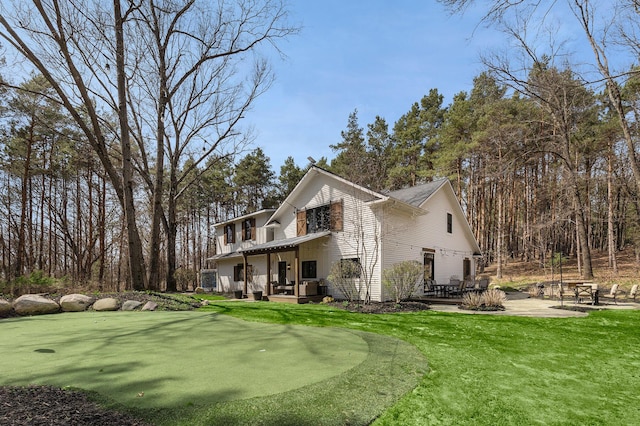 view of side of home with a lawn and a patio area