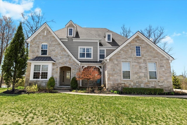 view of front of home with roof with shingles, a front yard, and stone siding