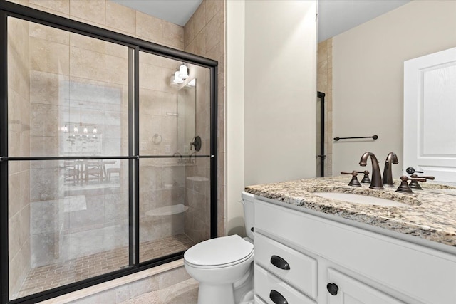 bathroom featuring vanity, a shower stall, and toilet