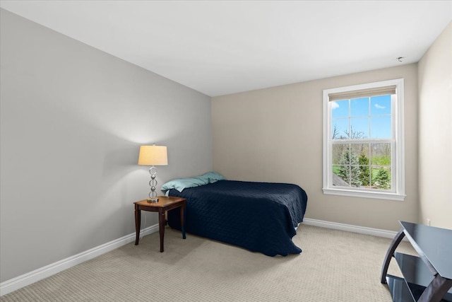 bedroom featuring baseboards and light colored carpet