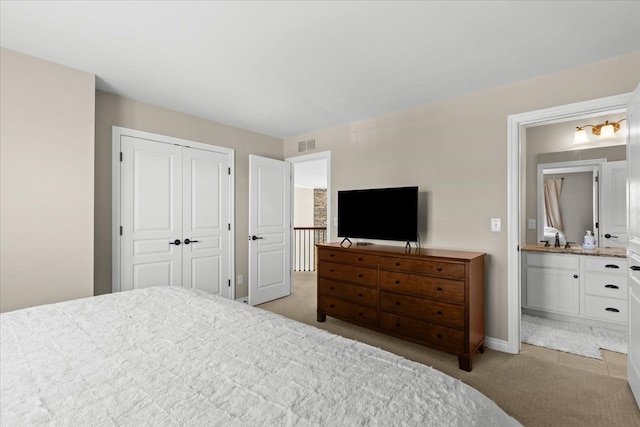 bedroom with visible vents, a sink, a closet, and light carpet