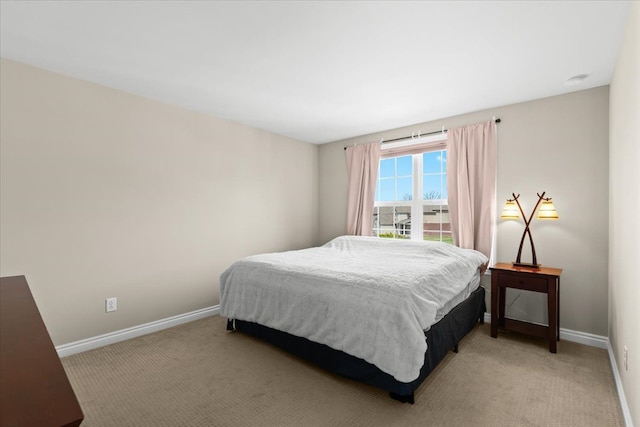 bedroom featuring baseboards and light carpet