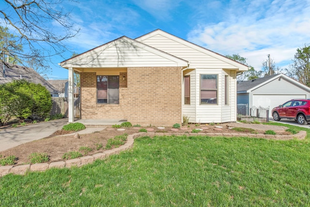 bungalow with a front yard and brick siding