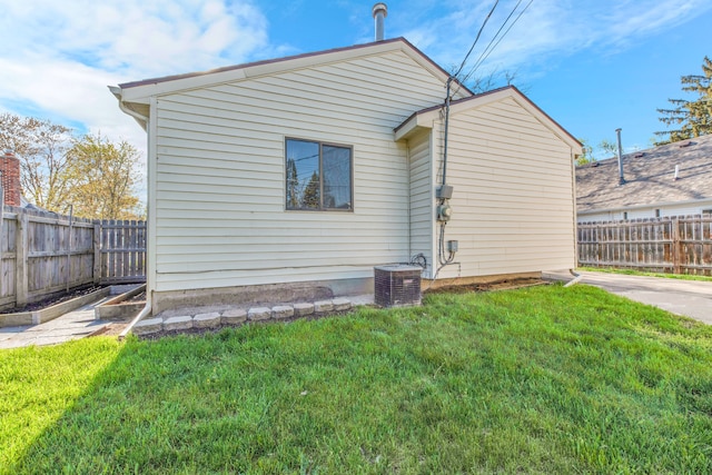 rear view of house featuring central AC, a yard, and fence