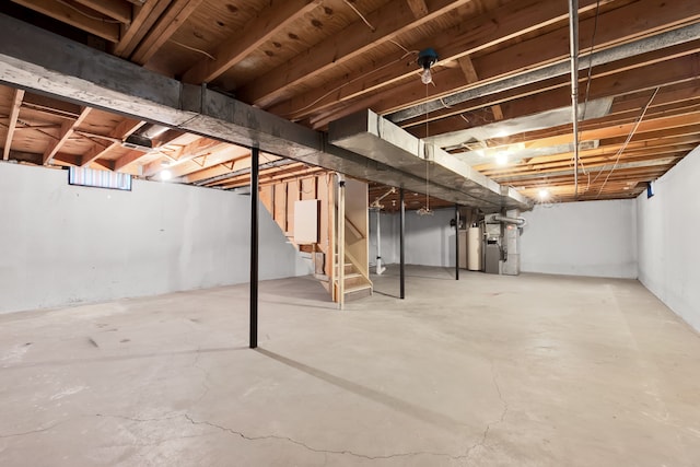 below grade area with heating unit, stairway, and gas water heater