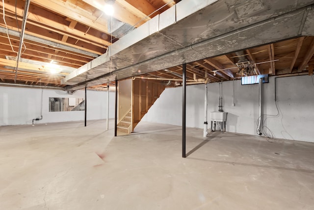 unfinished below grade area featuring a sink and stairs