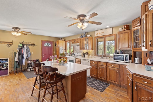 3620 Sharp Rd, Adrian, MI 49221 - kitchen featuring ceiling fan, a sink, a breakfast bar, white appliances, and a wealth of natural light