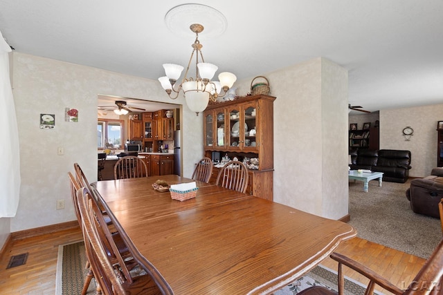 3620 Sharp Rd, Adrian, MI 49221 - dining area featuring baseboards, visible vents, light wood finished floors, and ceiling fan with notable chandelier