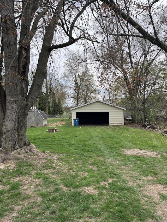 view of yard with a detached garage and an outbuilding